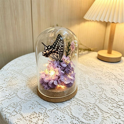 Glas Terrarium mit konservierten Blumen und Schmetterling