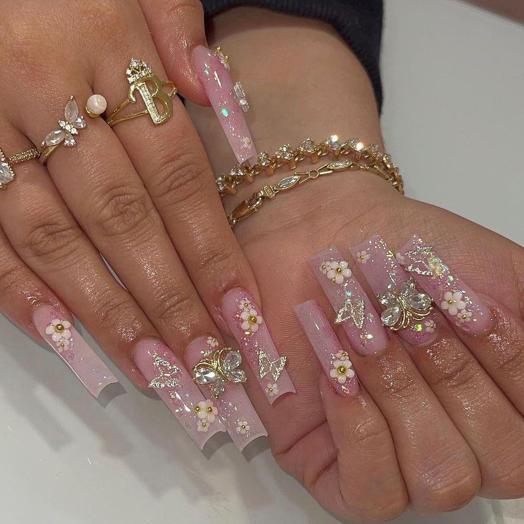 Kunstvolle Nagelverlängerungen mit Glitzer und floralen Akzenten Brehn