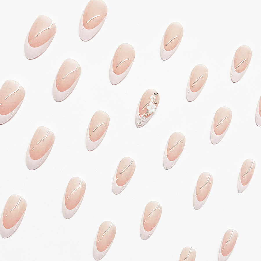 Kunstnagelset mit filigranen Blütenverzierungen und elegantem French Design Brehn