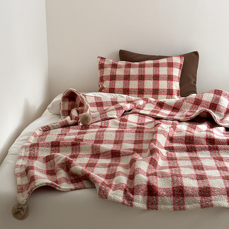 Kuscheldecke mit kariertem Muster und Bommelverzierung Brehn