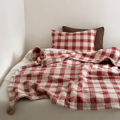 Kuscheldecke mit kariertem Muster und Bommelverzierung Brehn