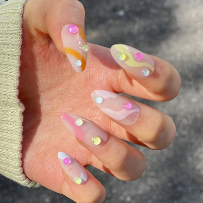 Kunstvolle Nagelverlängerungen mit buntem Design und Glitzerakzenten Brehn