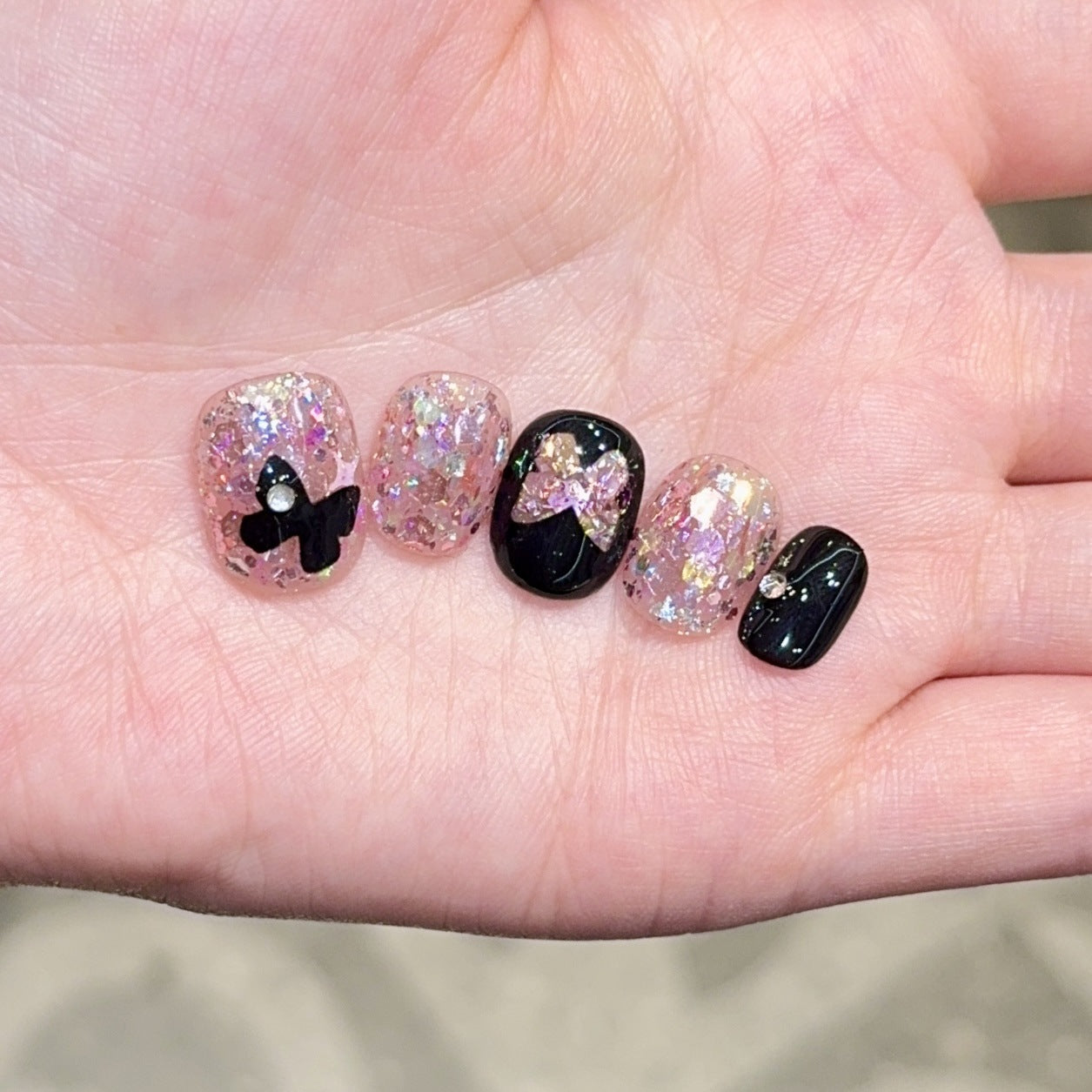 Kunstnägel mit Glitter- und Schleifenakzenten Brehn