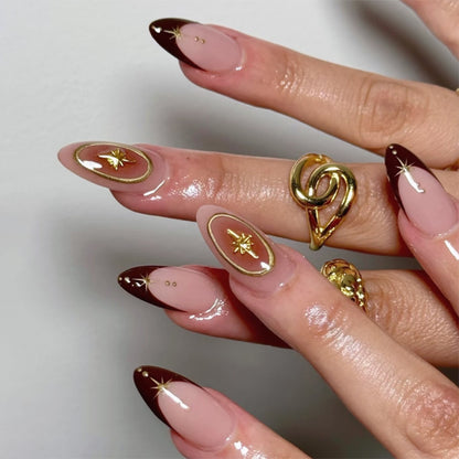 Kunstvolle Stiletto-Nägel mit eleganten Goldverzierungen Brehn