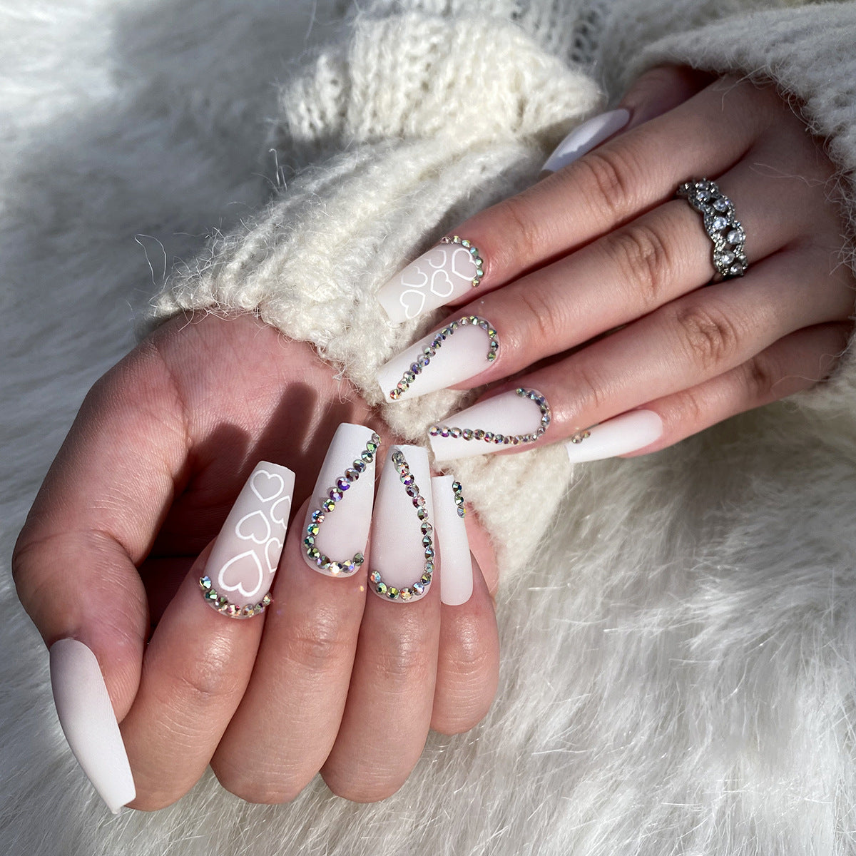Kunstvolle Nagelverlängerungen mit Herzen-Design und Glitzerakzenten Brehn
