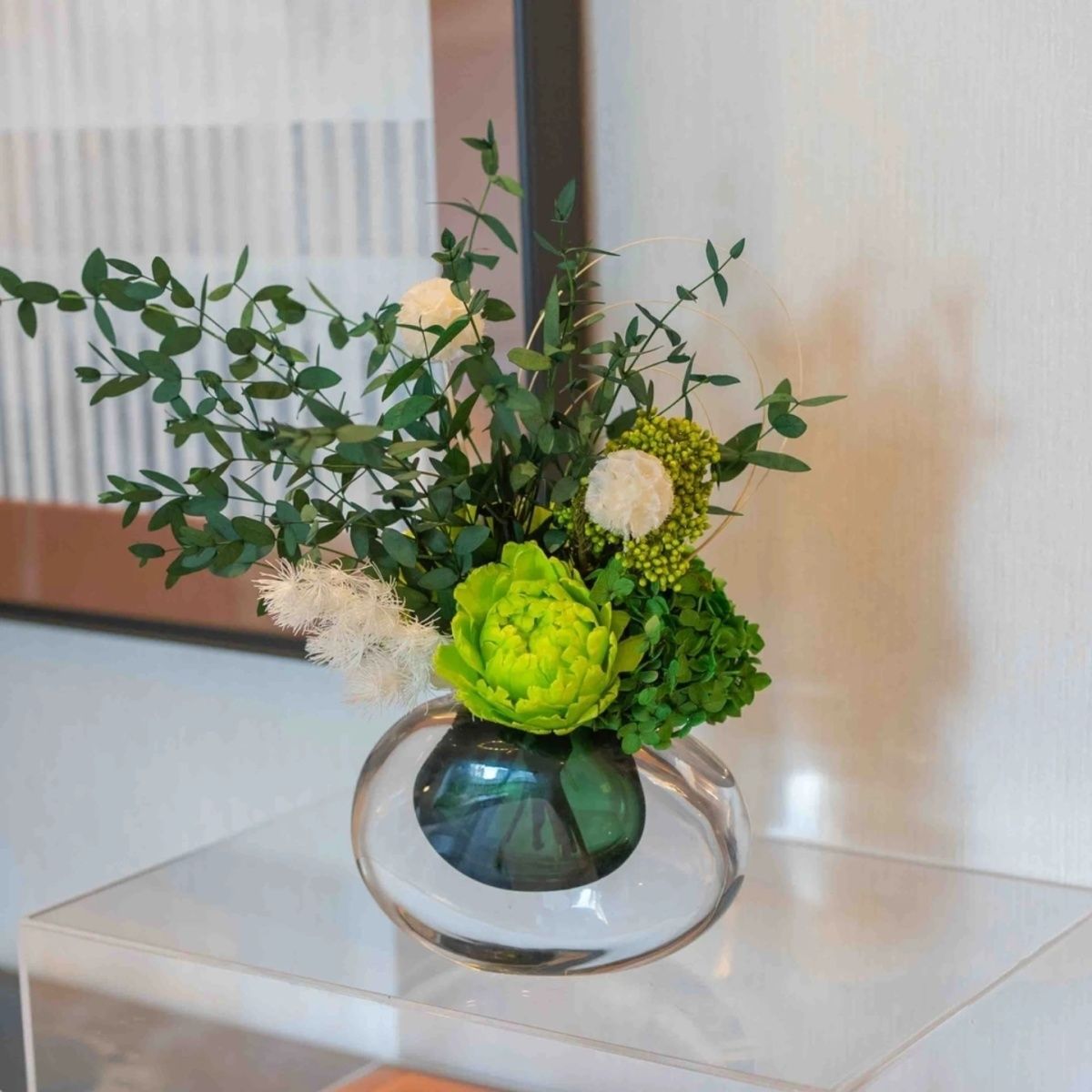 Lebensechte Blumenarrangement mit Glasvase