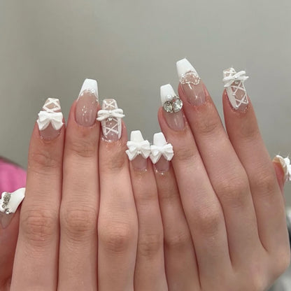 Kunstvolle Nagelkunst mit Schleifen- und Strassverzierungen Brehn