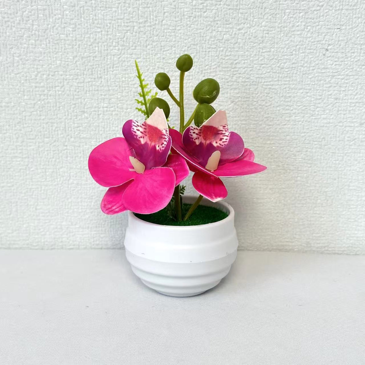 Lebensechte Miniatur-Orchideenarrangement