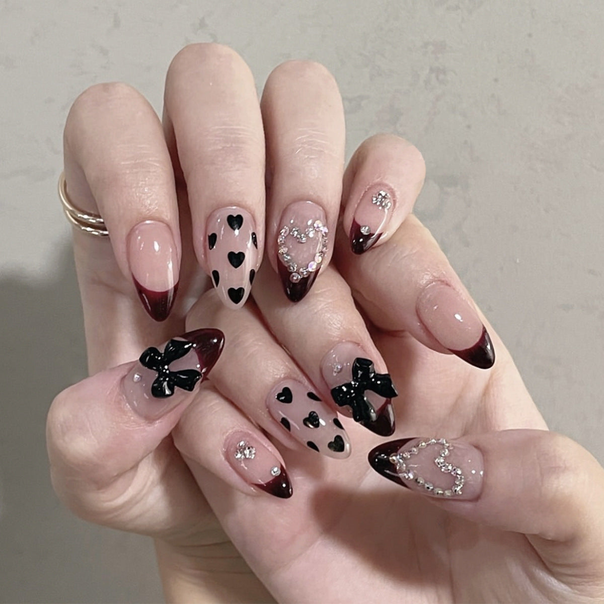 Künstlerische Stiletto-Nagelverlängerungen mit Herz- und Schleifenakzenten Brehn