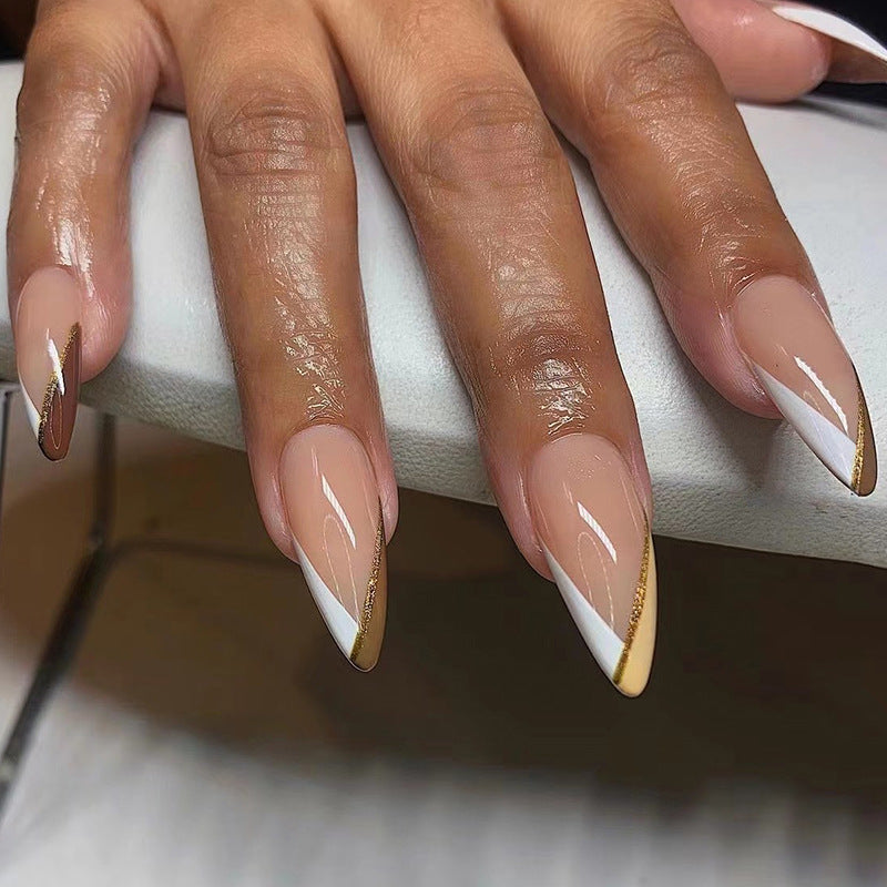 Kunstvolle Nagelkunst im eleganten Stiletto-Design mit goldenen Akzenten Brehn
