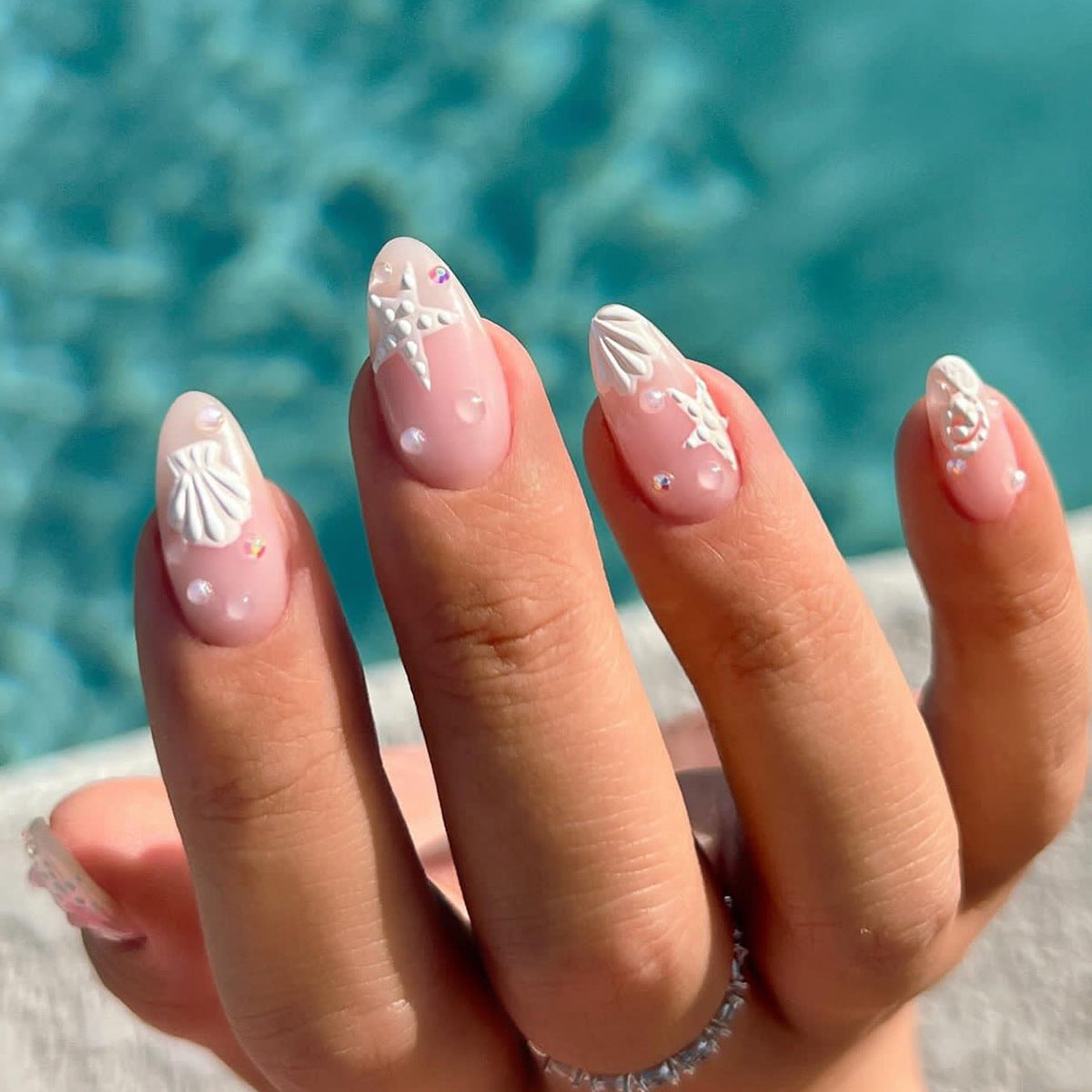 Kunstvolle Nagelgestaltungen mit Muschel- und Sternmotiv Brehn