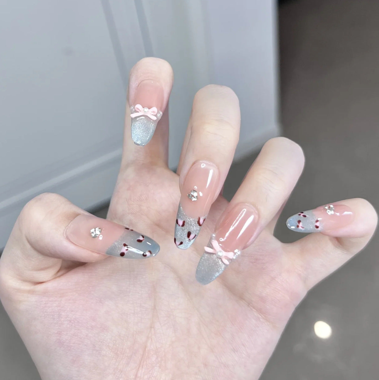 Künstlerisches Press-On-Nageldesign mit floralem und edelsteinbesetztem Akzent Brehn