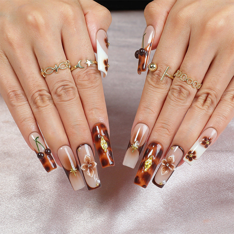 Elegantes Nagelkunstset mit floralen und goldenen Akzenten Brehn