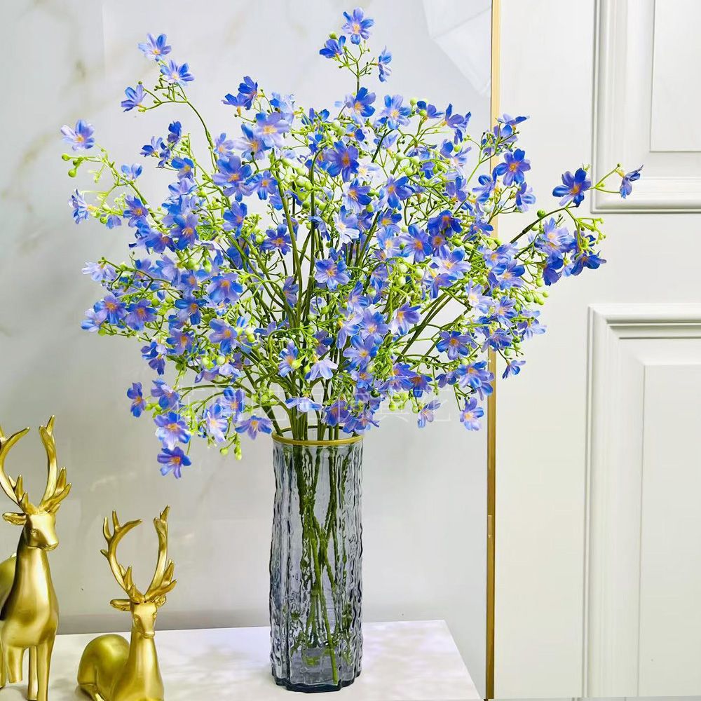 Künstliches Blumenarrangement mit dekorativer Glasvase