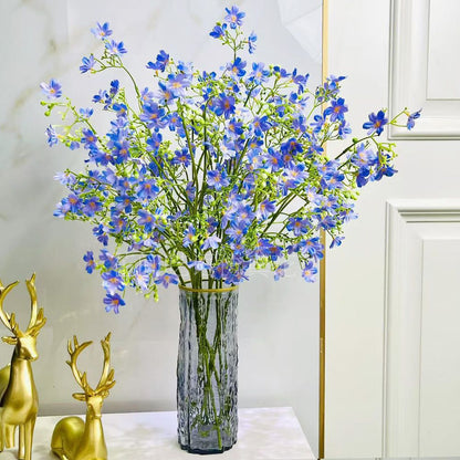 Künstliches Blumenarrangement mit dekorativer Glasvase