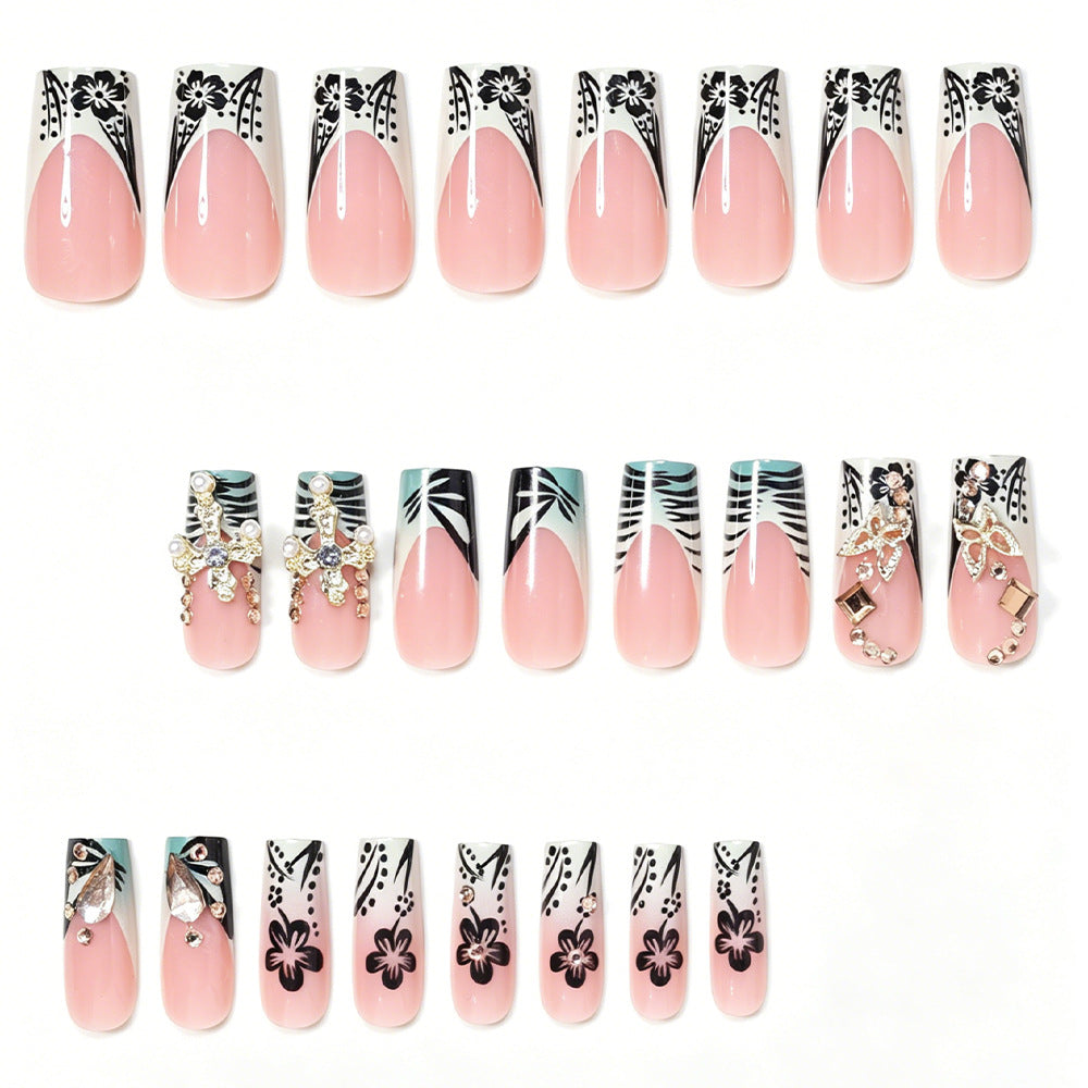 Künstlerisches Stiletto-Nageldesign mit floralen Akzenten und Edelsteinen Brehn