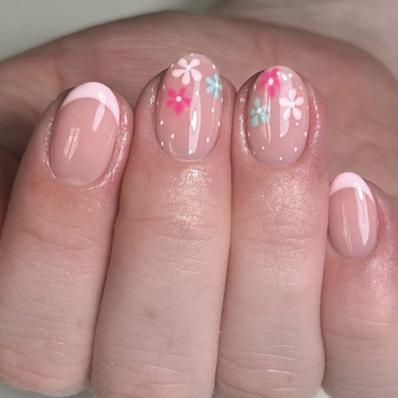 Kunstvolle Nagelverlängerungen mit bunten Blütenmotiven und Glitzer Brehn