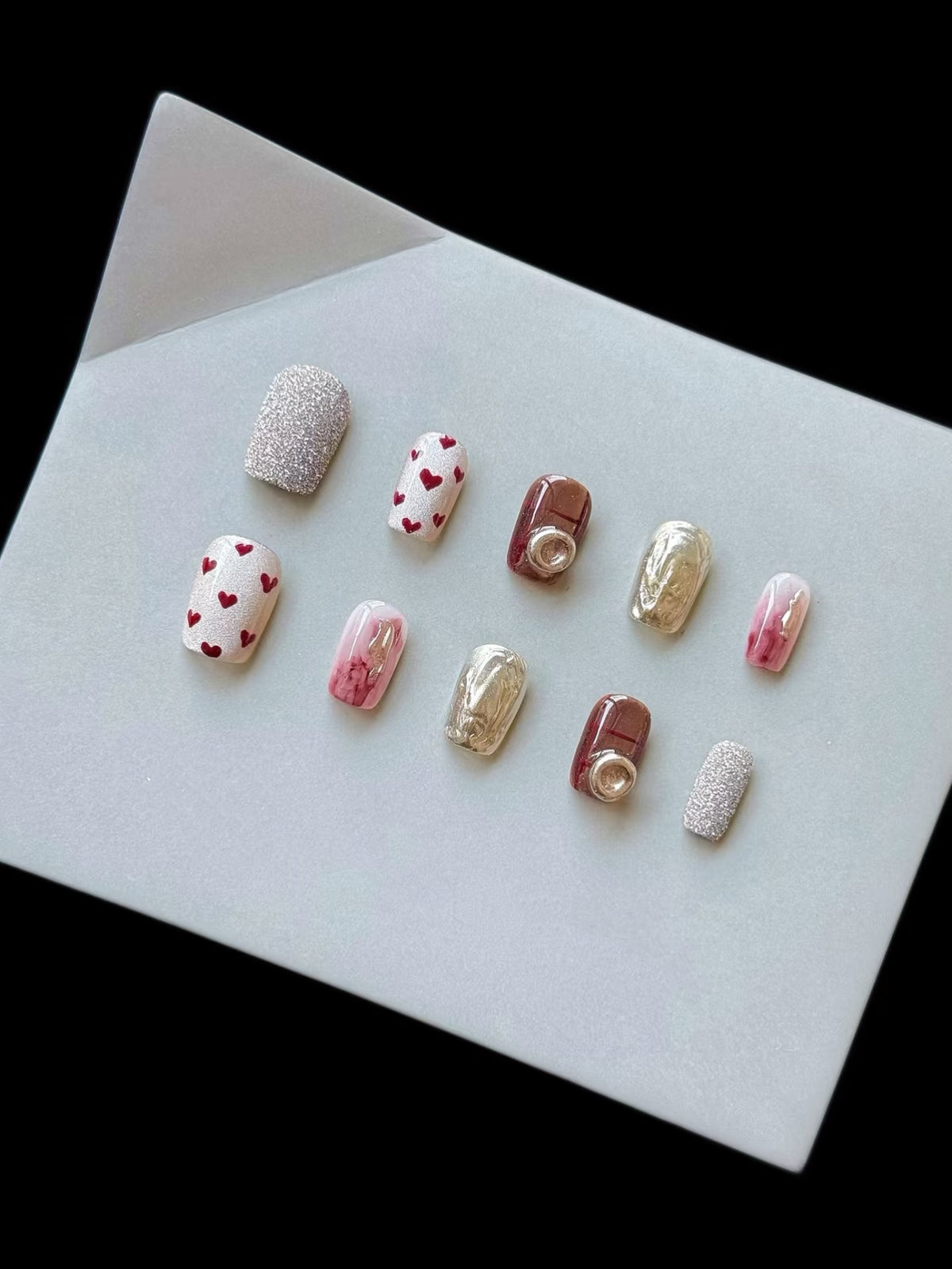 Künstlerisches Press-On-Nagelset mit Herz- und Glitzerelementen