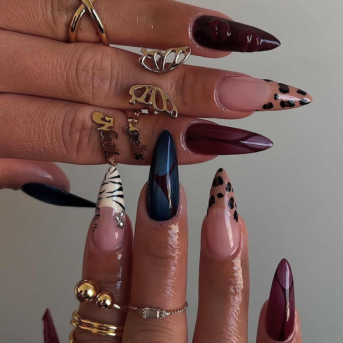 Künstlerische Stiletto-Nagelverlängerungen mit trendigem Tierdruck und Schmuckakzenten Brehn