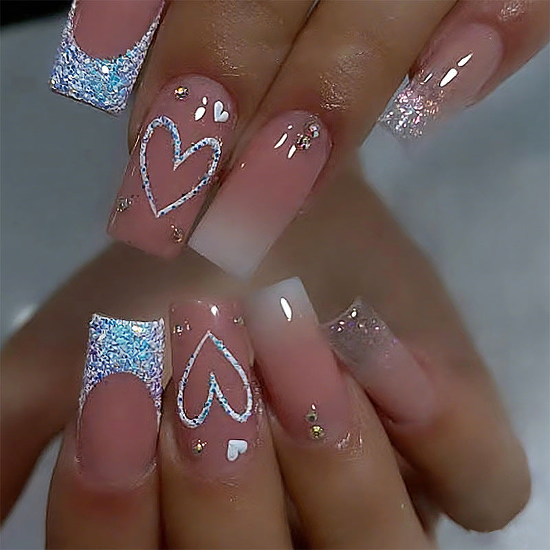 Kunstnägel mit funkelnden Herzmotiven und Glitzerdetails Brehn