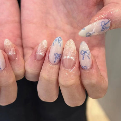 Kunstvolle Stiletto-Nägel mit zarten Schleifenverzierungen Brehn