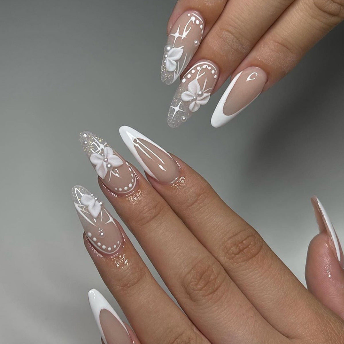 Kunstvolle Stiletto-Nägel mit floralen Motiven und Glitzerakzenten Brehn