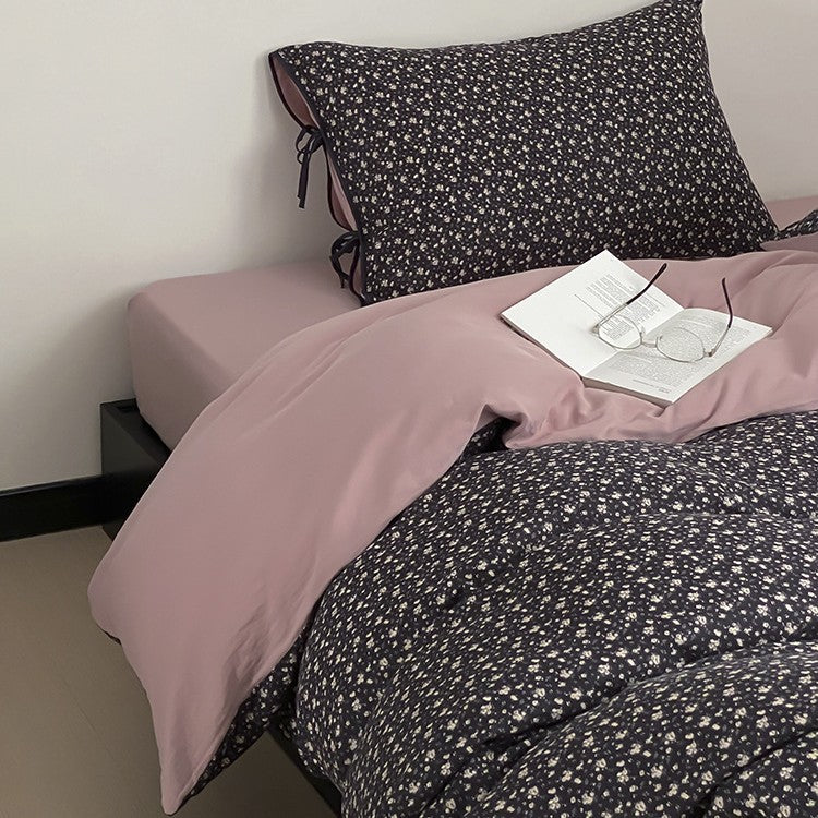 Wendbare Bettwäsche‑Garnitur aus Baumwollsatin mit feinem Blumenallover, kontrastierter Innenseite und dekorativen Schleifen