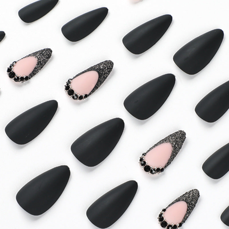 Kunstvolle Stiletto-Nägel mit elegantem Schwarz-Design und Glitzerakzenten Brehn