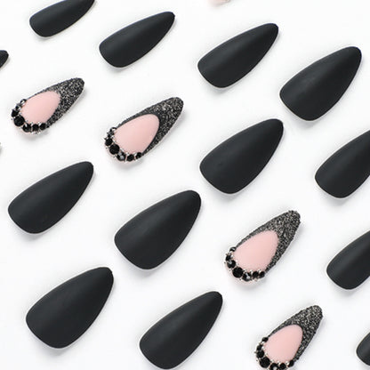 Kunstvolle Stiletto-Nägel mit elegantem Schwarz-Design und Glitzerakzenten Brehn