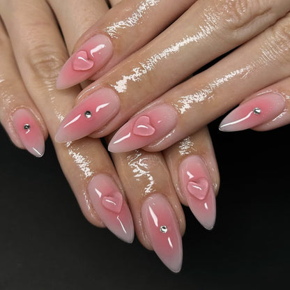 Kunstvolle Stiletto-Nägel mit Herzdesign und Glitzerakzenten Brehn