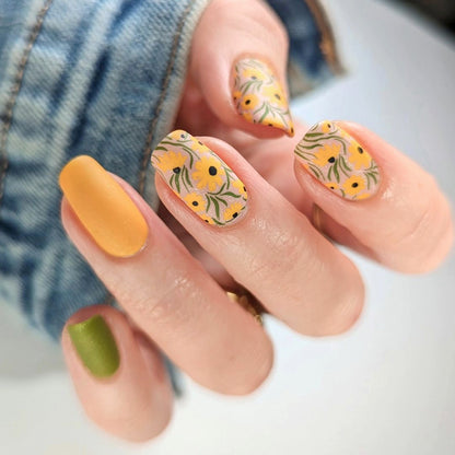 Kunstvolle Nagelverlängerungen mit floralen Designs und kreativen Farbakzenten Brehn