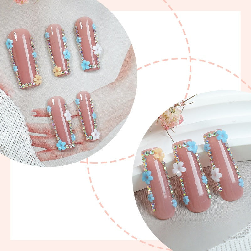 Kunstnagelset mit zarten Blumenverzierungen und Glitzerakzenten Brehn