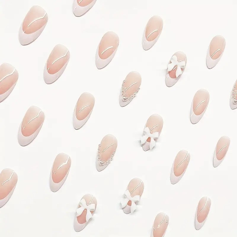 Künstlerisches Press-On-Nageldesign mit Schleifenakzenten Brehn