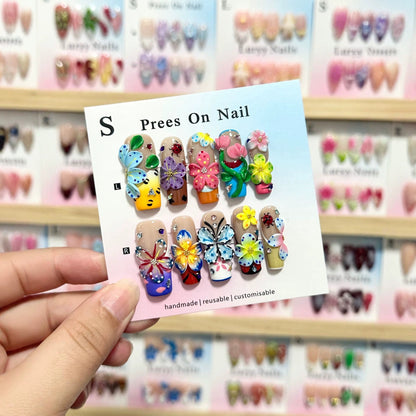 Künstlerisches Press-On Nagelkunstset mit lebhaften Blumen- und Schmetterlingsdesigns