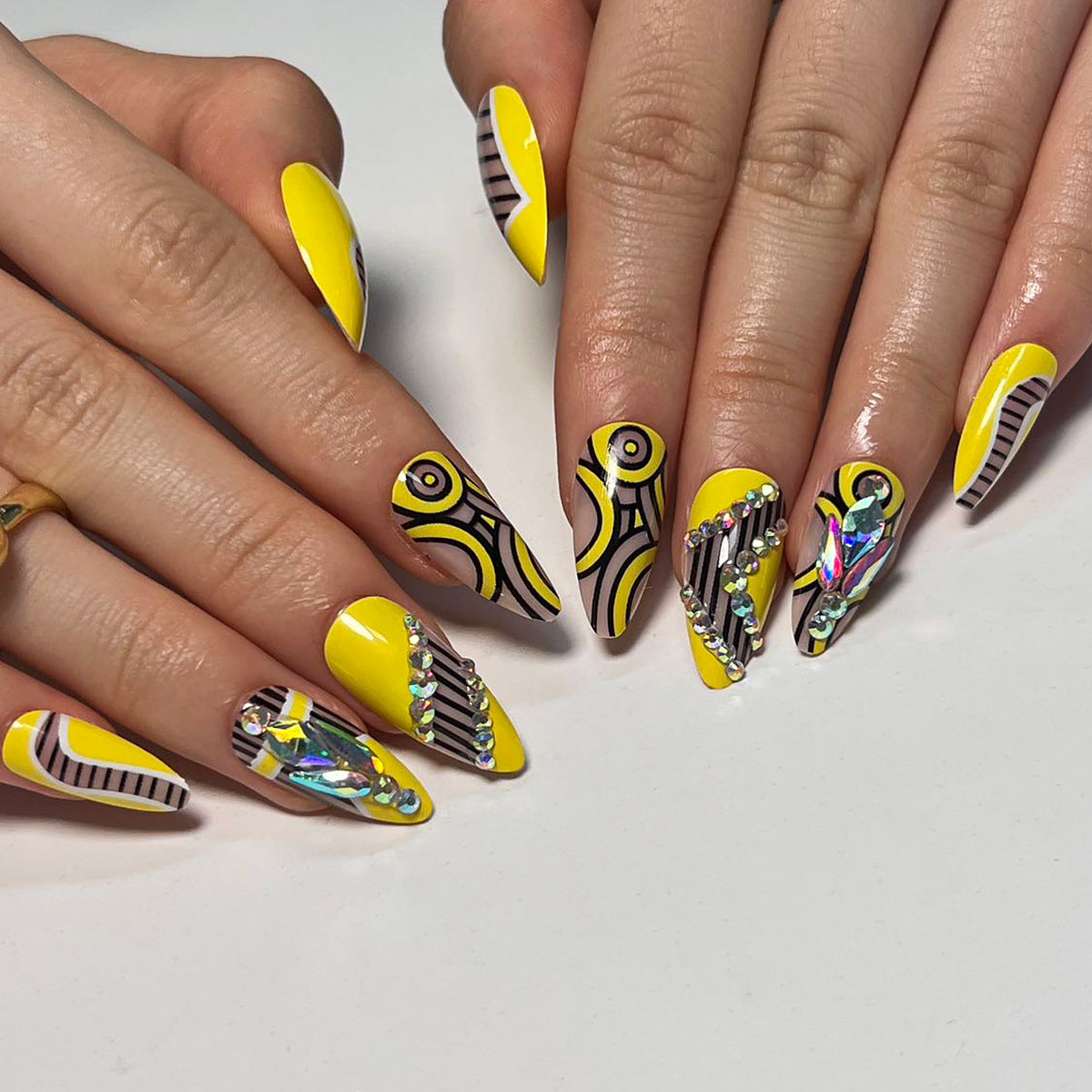 Kunstvolle Nagelverlängerungen mit geometrischem Design und Glitzerakzenten Brehn