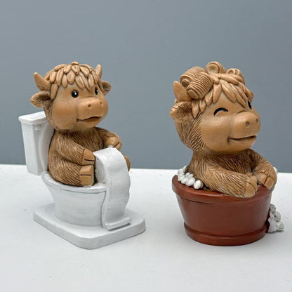 Lustige Dekofigur eines Hochlandrinds auf Toilette Brehn