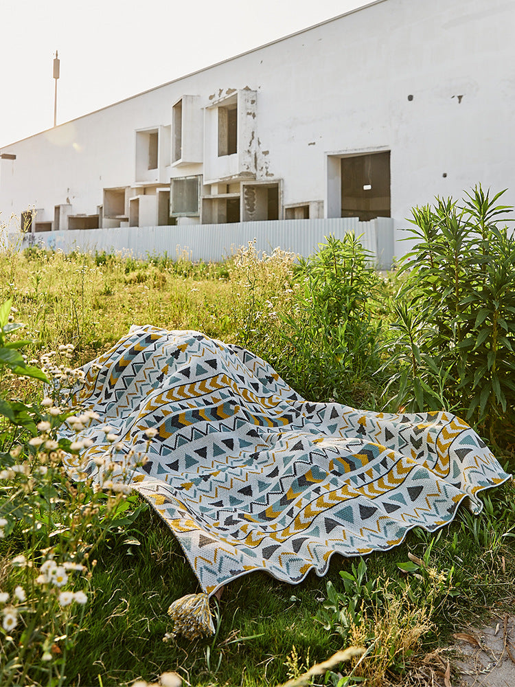 Gemusterte Wohndecke im Ethno-Strickdesign mit Quasten
