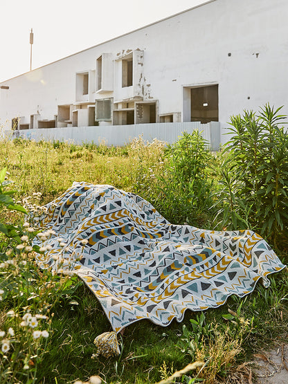 Gemusterte Wohndecke im Ethno-Strickdesign mit Quasten