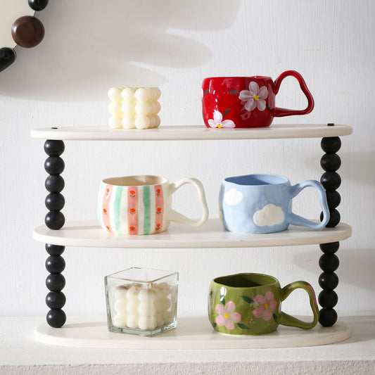 Keramikbecher mit handbemalten Streifen- und Blumen-Design