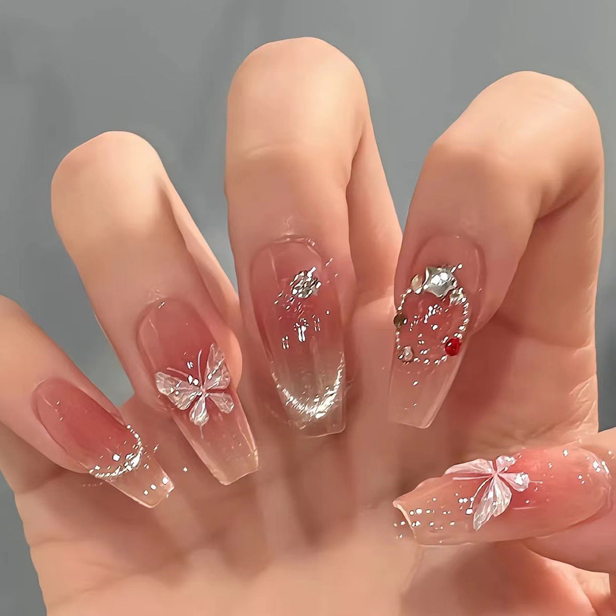 Künstliche Nagelverlängerungen mit floralem Design und funkelnden Akzenten Brehn