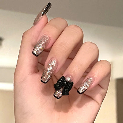 Kunstvolle Nagelverlängerungen mit Glitzer- und Schleifenakzenten Brehn