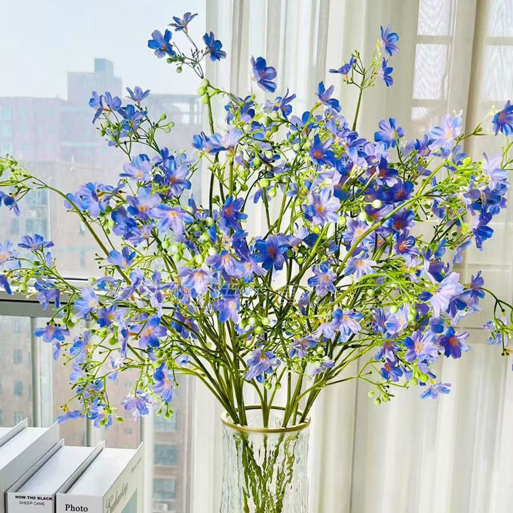 Künstliches Blumenarrangement mit dekorativer Glasvase
