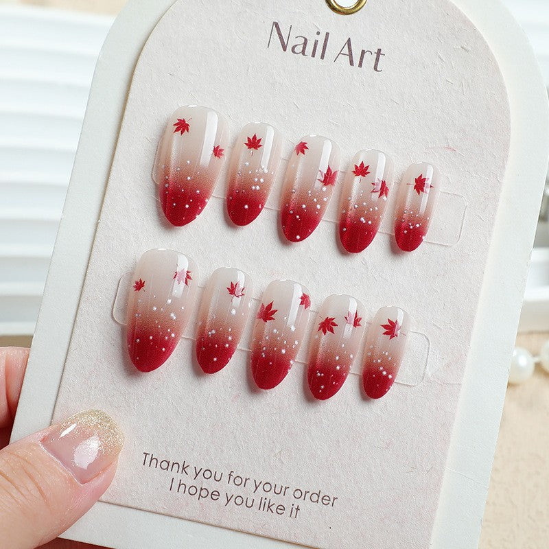 Kunstnagelset mit elegantem Rot-Ombré-Look und zarten Ahornblättern Brehn