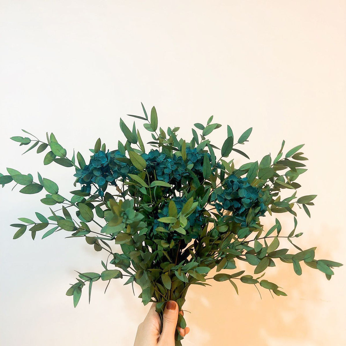 Lebensechter Blumenstrauß mit grünen Blättern
