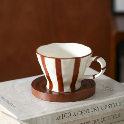 Skulpturale Keramik-Kaffeetasse mit geschwungenem Rand und markantem Streifendekor