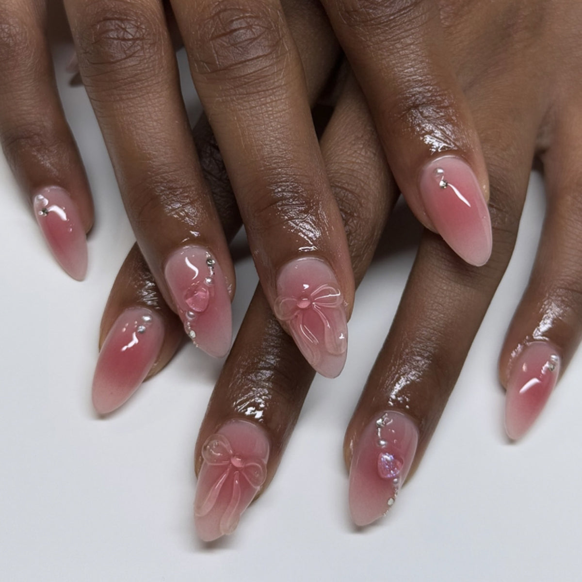 Kunstvolle Nagelverlängerungen mit zarten Blütenakzenten und Glitzer Brehn
