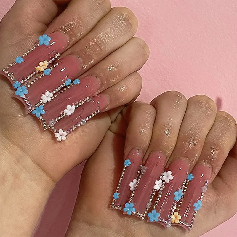 Kunstnagelset mit zarten Blumenverzierungen und Glitzerakzenten Brehn