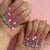 Kunstnagelset mit zarten Blumenverzierungen und Glitzerakzenten Brehn