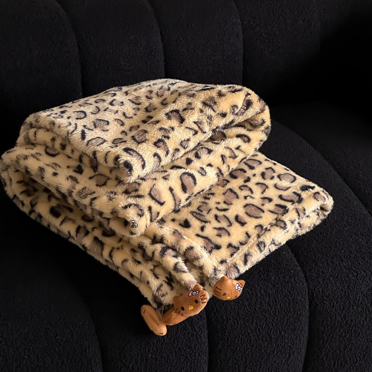 Kuschelige Wohndecke aus Microfleece mit Leo-Print und Plüschanhängern