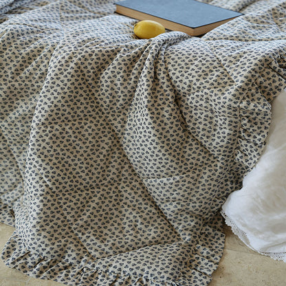 Leicht gesteppte Wohndecke im Vintage‑Blumenprint mit Rüschenrand